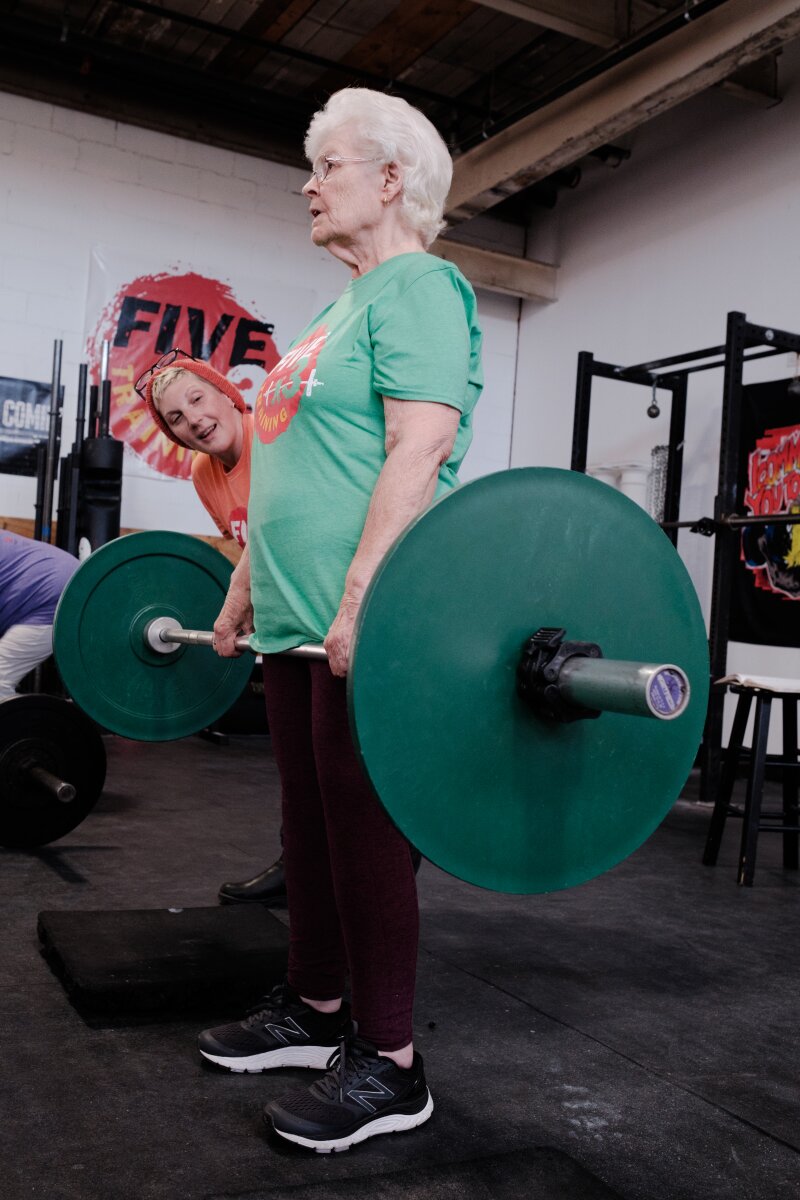 A young ⁢couple smiles⁣ outside ‍their tiny home, ​surrounded by ⁣greenery.