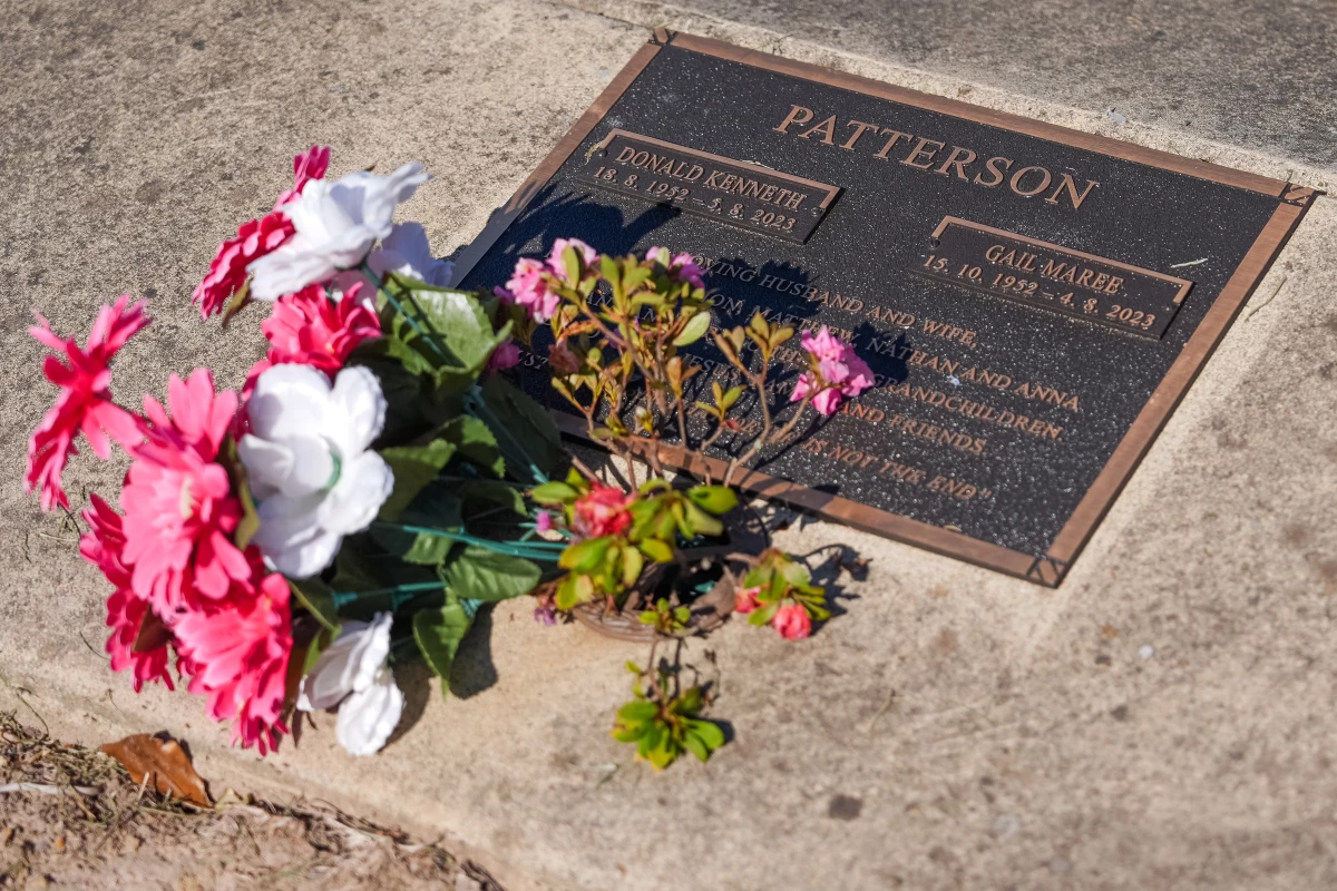 Flowers rest on the grave site for Don and Gail Patterson at the Korumburra General Cemetery during their daughter-in-law's trial in May 2025.