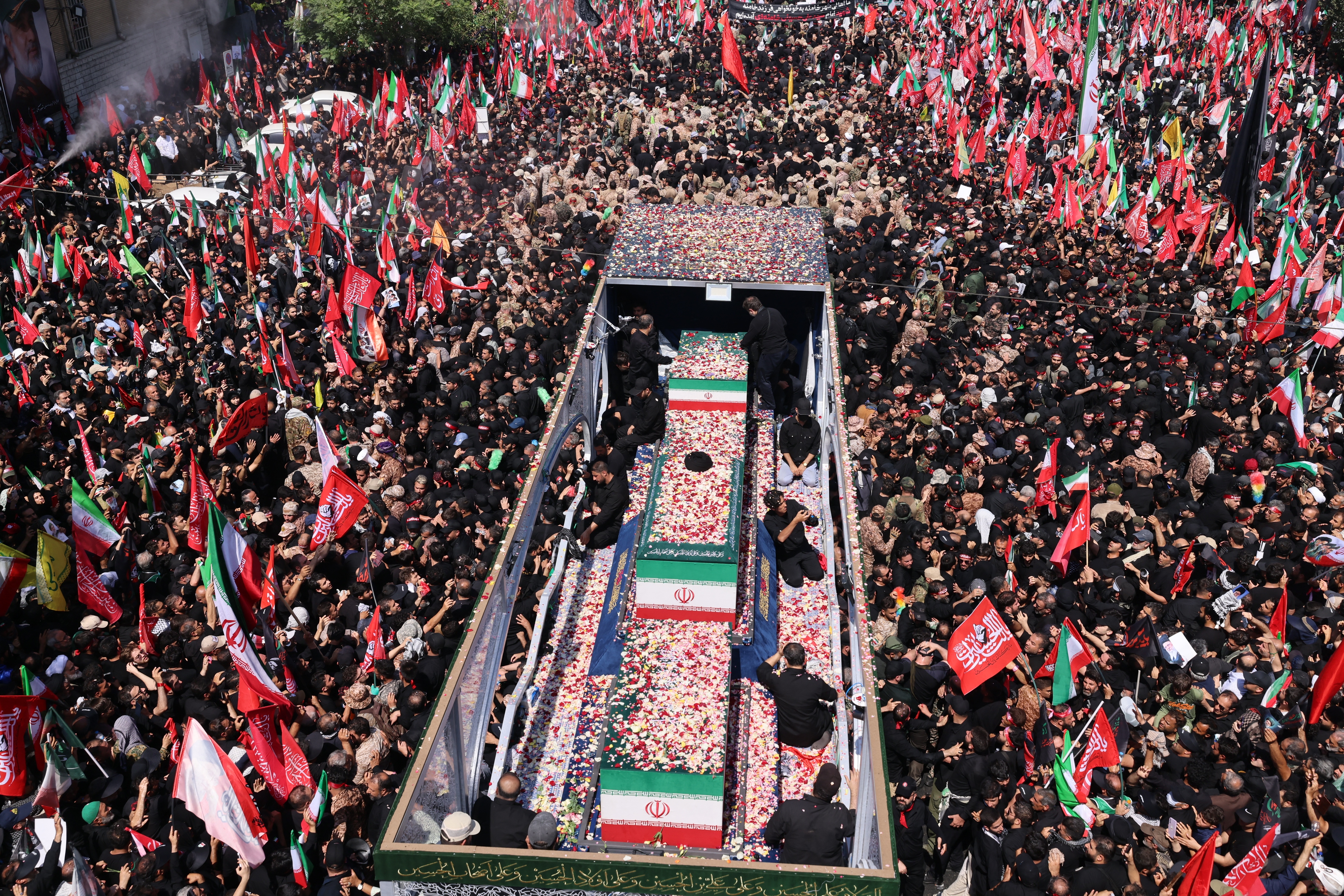Flower petals are thrown on the coffins of Iran