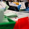 Election workers open and inspect mail-in ballot envelopes for Arizona’s 2024 general election inside the Maricopa County Tabulation and Election Center in Phoenix.