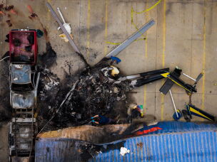In this aerial view, people investigate the aftermath of a news helicopter crash in Chatsworth, a neighborhood in Los Angeles, on Wednesday, Sept. 16, 2026.
