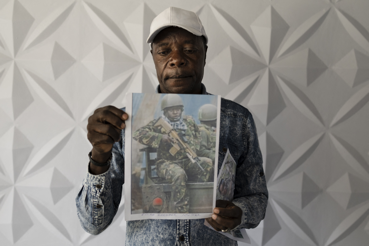 Charles Ojiambo Mutoka, 72, stands with portraits of his son Oscar, who was killed in Aug. 2025, during a press conference in Nairobi on Jan. 27, 2026, where relatives of conscripts called on the government to urgently repatriate their loved ones.