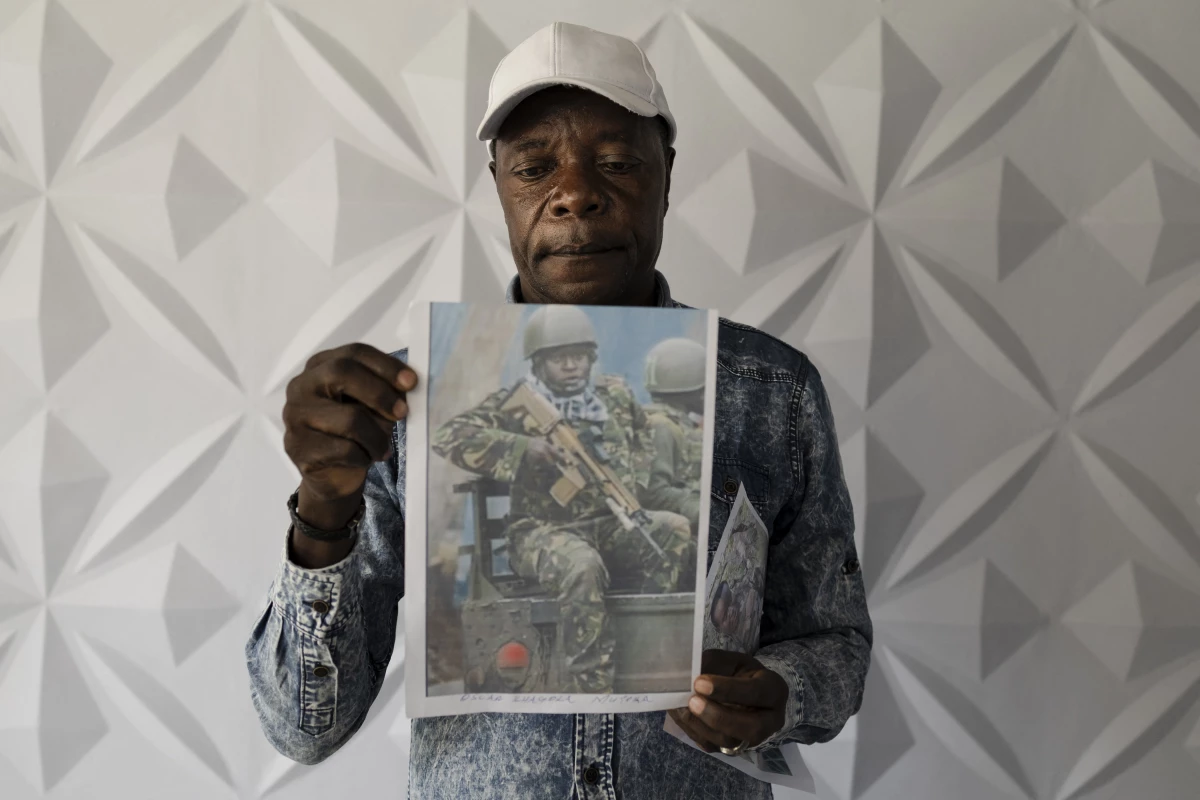Charles Ojiambo Mutoka, 72, stands with portraits of his son Oscar, who was killed in Aug. 2025, during a press conference in Nairobi on Jan. 27, 2026, where relatives of conscripts called on the government to urgently repatriate their loved ones.