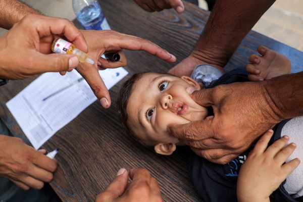 A young child is restrained before receiving a vaccination for polio in Deir el-Balah in the central Gaza Strip on Sept. 4. It was during the first round of a massive vaccination campaign led by the World Health Organization and the United Nations.