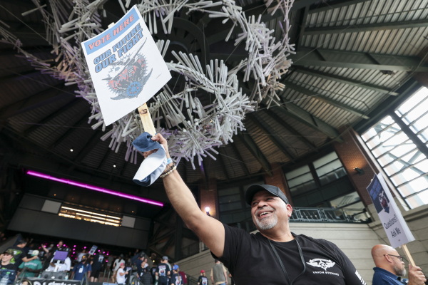 Manny Briones, an iron machinist from Seattle, welcomes members and supporters of the International Association of Machinists and Aerospace Worker Union (IAM) District 751 for an early strike-sanction vote at T-Mobile Park in Seattle, Washington on July 17.
