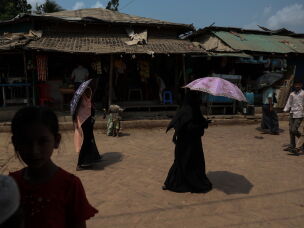 People walk past vendor stalls in a Rohingya refugee camp in Cox's Bazar, Bangladesh, April 21, 2026.