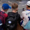 Hugo Winwood-Smith, right, Hardy Macpherson and Edan Abou, left, all 11-years-old, use their phones while sitting outside a school in Sydney on Monday, Dec. 8, 2025.
