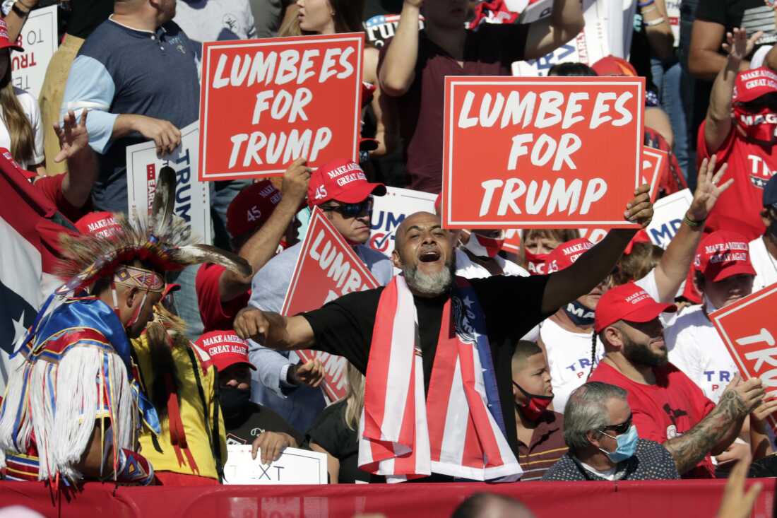 Supporters hold "Lumbees for Trump" signs as President Donald Trump speaks during a campaign rally at the Robeson County Fairgrounds in Lumberton, N.C.