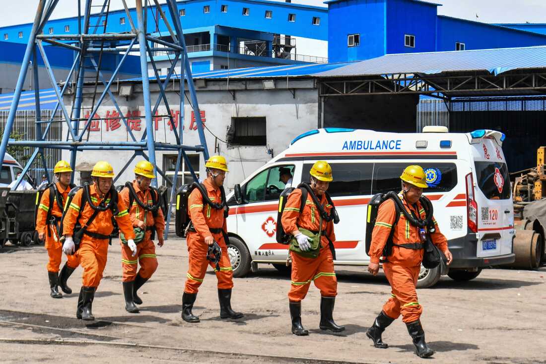 Nesta foto divulgada pela Agência de Notícias Xinhua, trabalhadores passam por uma ambulância após uma explosão na mina de carvão Liushenyu da cidade de Changzhi, no condado de Qinyuan, província de Shanxi, norte da China, no sábado, 23 de maio de 2016.