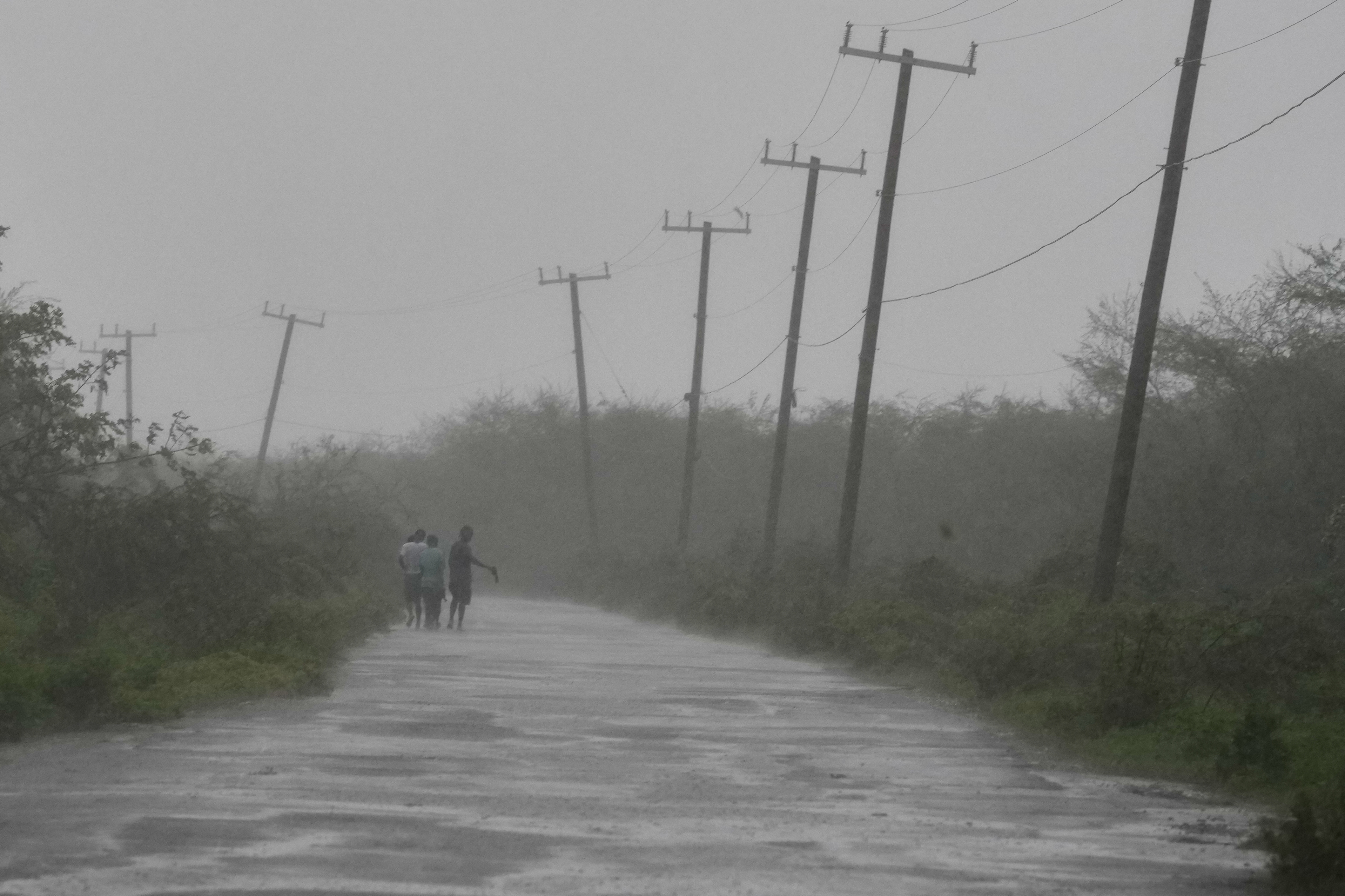 People walk along a road during the passing of Hurricane Melissa in Rocky Point, Jamaica, on Tuesday. (AP)