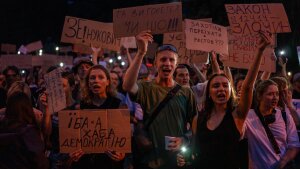 People chant while holding banners during a protest against a law targeting anti-corruption institutions in central Kyiv, Ukraine on Tuesday.
