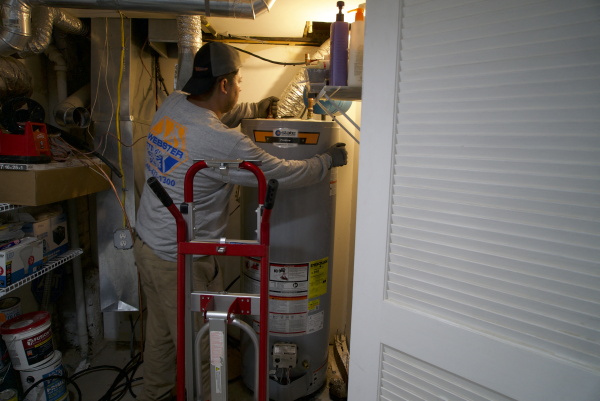 A technician removes a gas water heater from a home in Washington, DC.