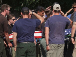 The body of a firefighter who died battling wildfires near the Colorado-Utah border is carried during a procession in Grand Junction, Colo., on June 29.