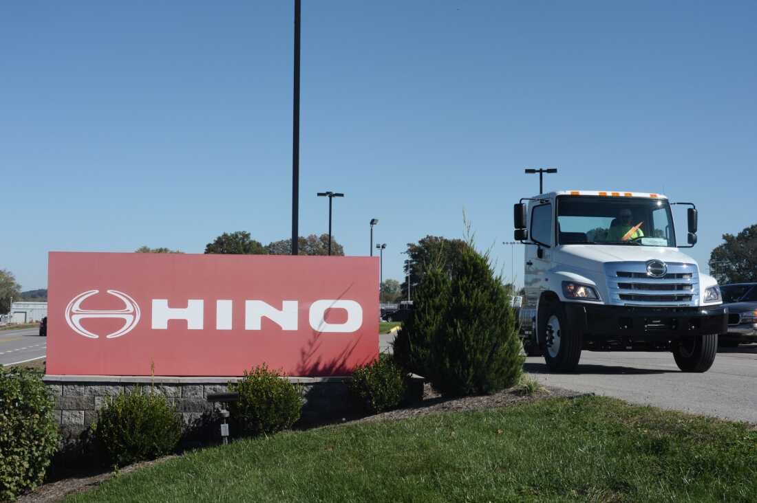 A truck passes a Hino sign in Williamstown, W.V., in 2017. The truck manufacturer, a Toyota subsidiary, has agreed to plea guilty to federal conspiracy charges and pay a total of $1.6 billion to settle civil claims after regulators discovered it was submitted fraudulent data to evade emissions standards.
