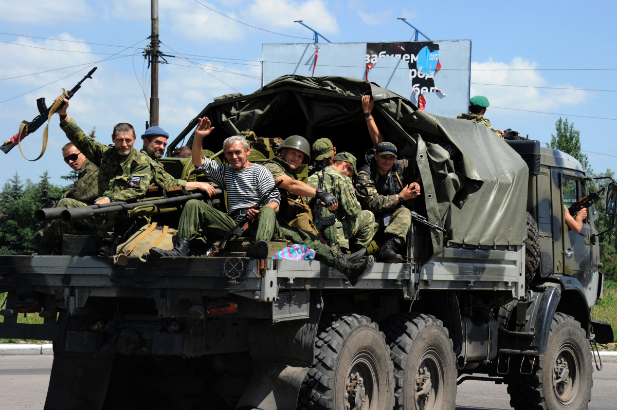Pro-Russian fighters sitting atop a truck drive past a checkpoint in Makiivka, near Donetsk, on July 11, 2014.