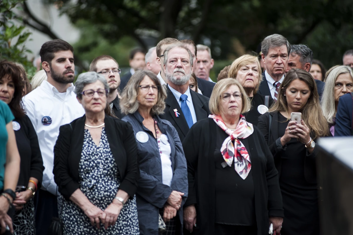 Michael Keating, center in the second row, stands during the wreath laying at the 9/11 memorial at the Boston Public Garden. His mother, Barbara Ann Keating, was killed during the September 11th attacks in 2001. September 11, 2016.