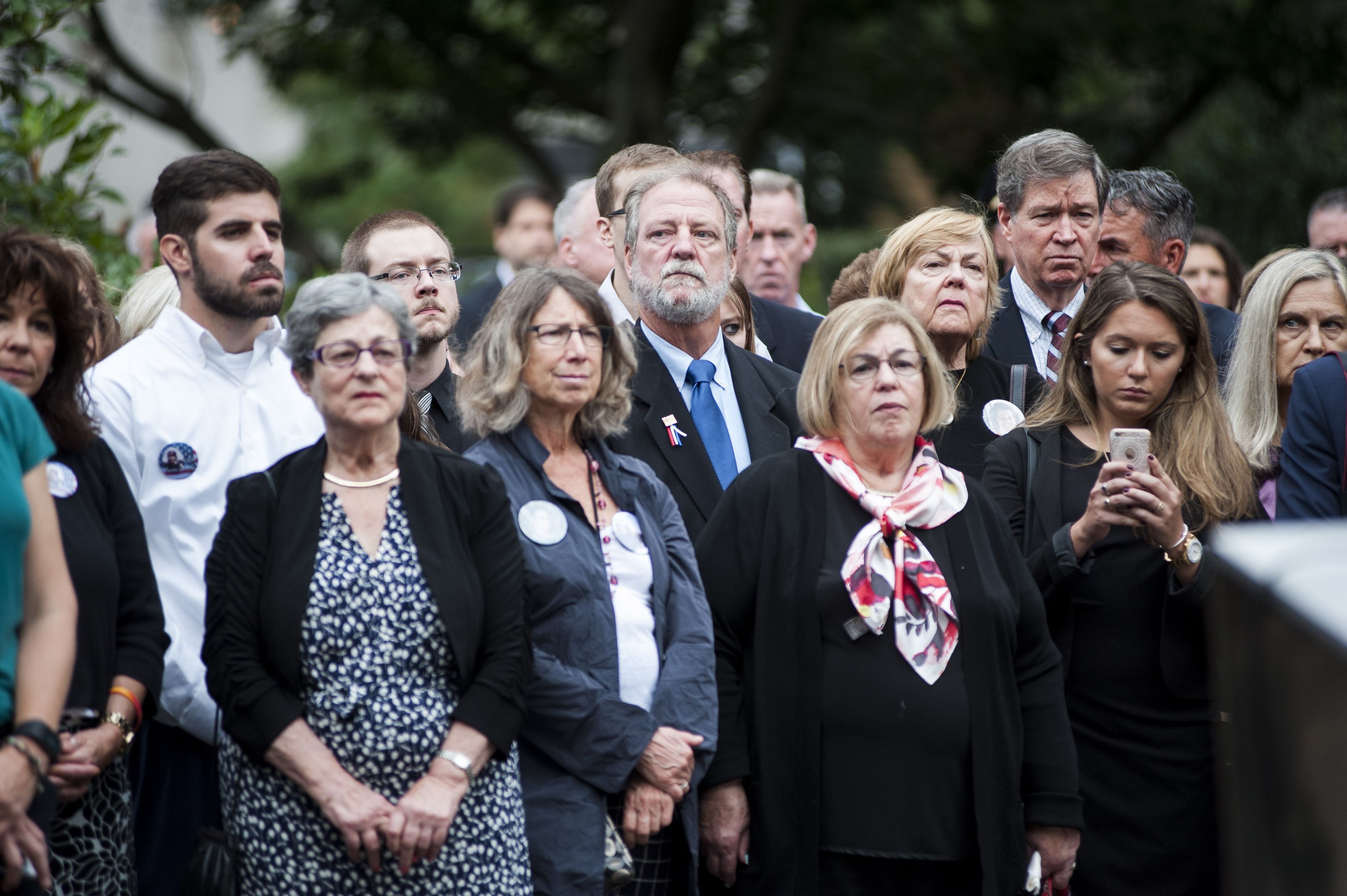 Michael Keating, center in the second row, stands during the wreath laying at the 9/11 memorial at the Boston Public Garden. His mother, Barbara Ann Keating, was killed during the September 11th attacks in 2001. September 11, 2016.