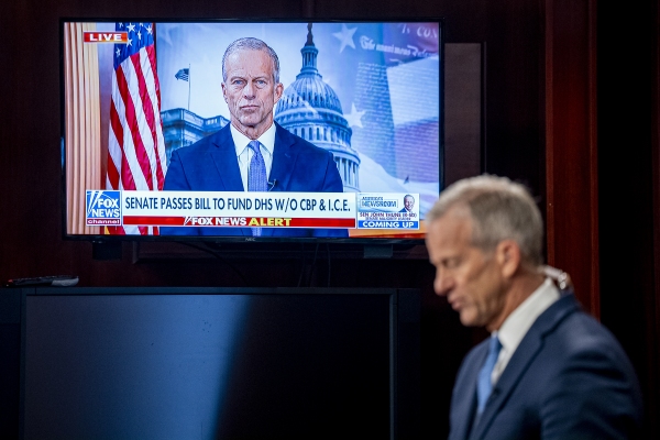 A large TV screen shows Senate Majority Leader John Thune as he sits near it while preparing for a television interview on April 2.