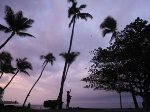 Ryanna Fry takes a picture of clouds as Hurricane Nolo sits nearby in Kona, Hawaii, Friday, Sept. 25, 2026.