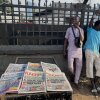 People stand near a display local newspapers on the street of Lagos with headlines on gunmen abducting schoolchildren and staff of the St. Mary's Catholic Primary and Secondary School in Papiri community in Nigeria, Saturday, Nov. 22, 2025.