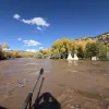 Aaron Schenk rafted down the Animas River through southwestern Colorado into New Mexico on Friday. He passed by an inundated event space.