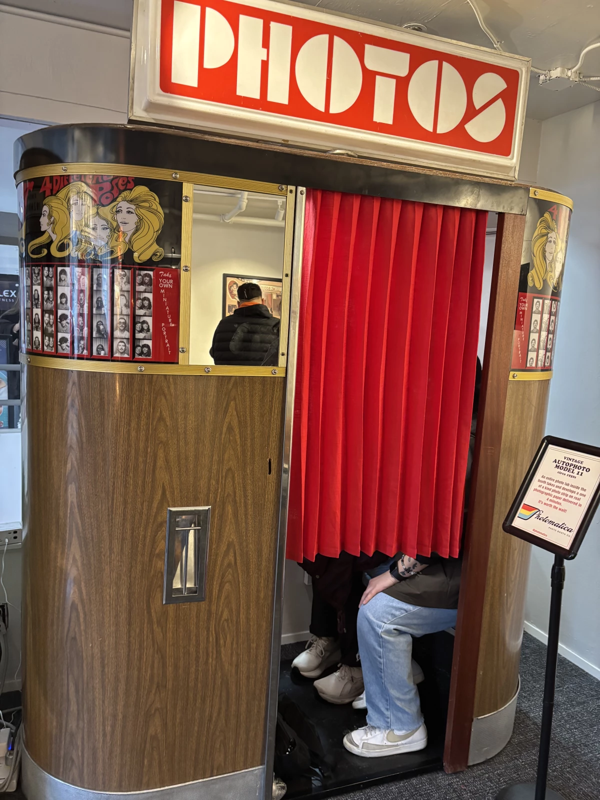 Guests get cozy in a vintage machine at the Photo Booth Museum by Photomatica in San Francisco.