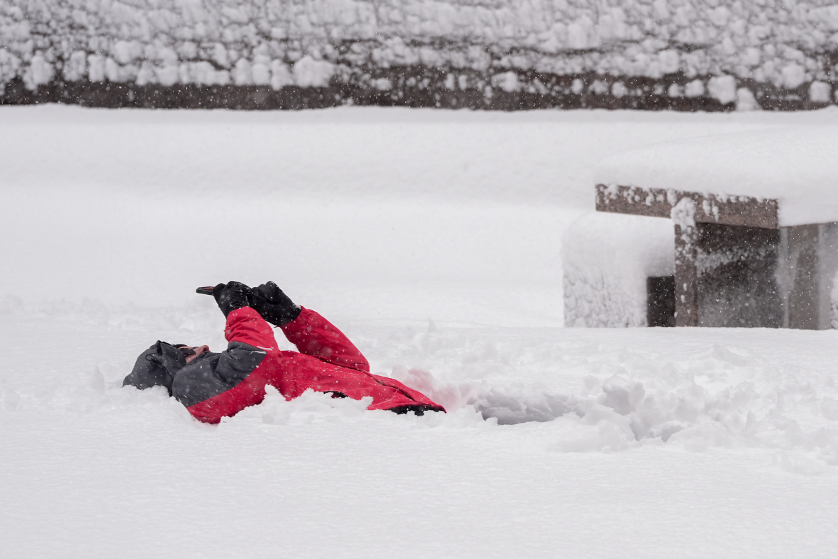 A person makes a recording while laying in the snow in lower Manhattan during a snow storm on Feb. 23 in New York.