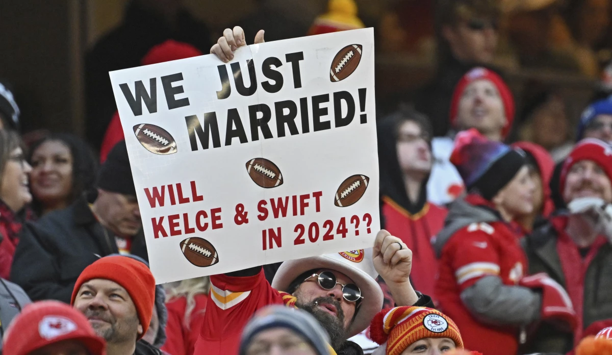 Fans hold up a sigh about Travis Kelce and Taylor Swift during a Kansas City Chiefs home game in December 2023, months into their relationship.