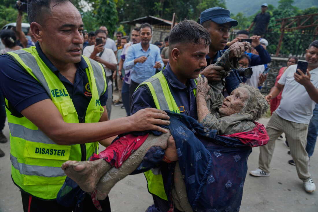 Rescuers carry a victim of flash flooding to safety along the Trishuli River in Nepal's Nuwakot district, Wednesday, Aug. 26, 2026.