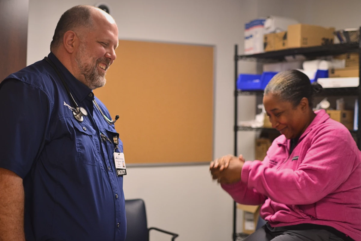 Dr. Brent Smith, left, a physician at a primary care clinic at Delta Health System in Greenville, Miss. laughs with a co-worker.