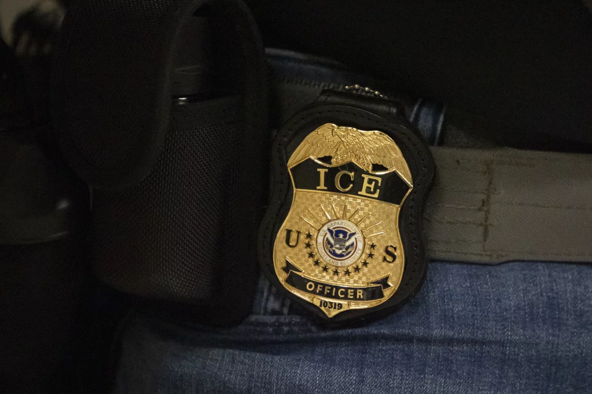 A federal agent wears a badge of Immigration and Customs Enforcement while standing outside an immigration courtroom at the Jacob K. Javits Federal Building in New York City, on June 10.