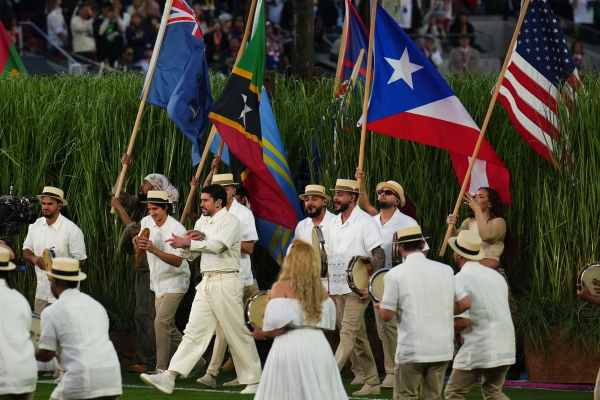 Bad Bunny performs during halftime of the NFL Super Bowl on Sunday. People are carrying flags from North, Central, and South America.