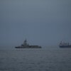 A United Arab Emirates navy vessel patrols next to cargo ships and oil tankers in the Strait of Hormuz, as seen from Khor Fakkan, United Arab Emirates, March 11.