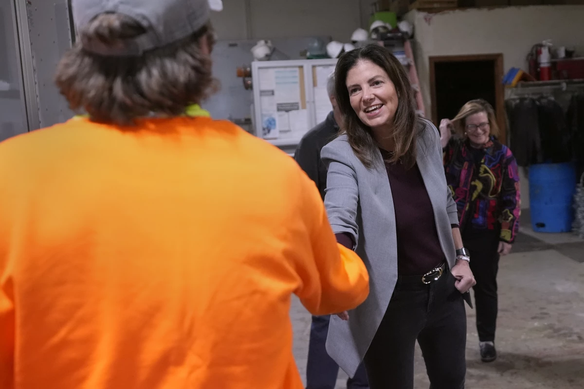 Republican Kelly Ayotte shakes hands with an employee during a visit to a local concrete coating business on Oct. 16 in Manchester, N.H.