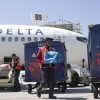 Delta Air Lines ramp temsilcisi Mike Davis, 13 Mayıs 2026'da Atlanta'daki Atlanta Hartsfield Jackson Uluslararası Havalimanı'nda asfaltta çalışırken yolcu bagajlarını bagaj arabasına yüklemeye hazırlanıyor.