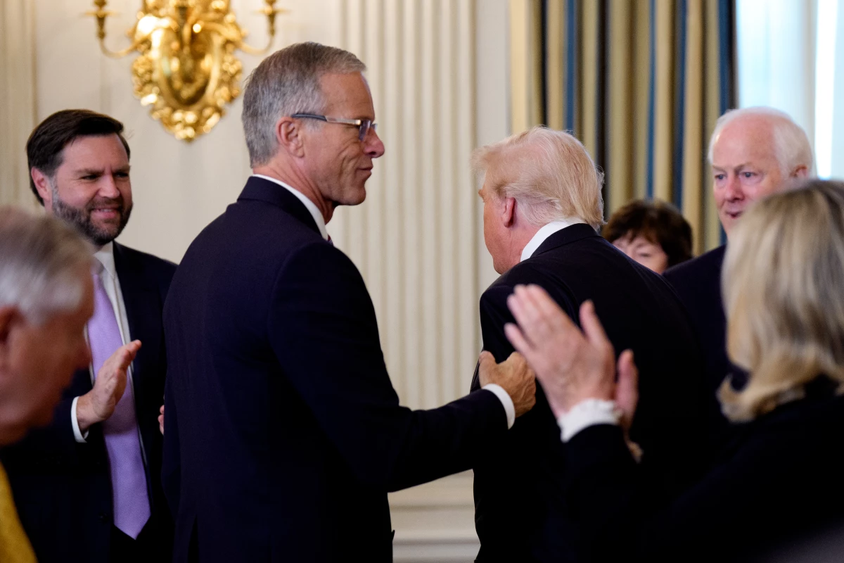 Senate Majority Leader John Thune, R-S.D., greets President Trump as he arrives to speak with Senate Republicans at a breakfast in the State Dining Room of the White House on Nov. 5, 2025.
