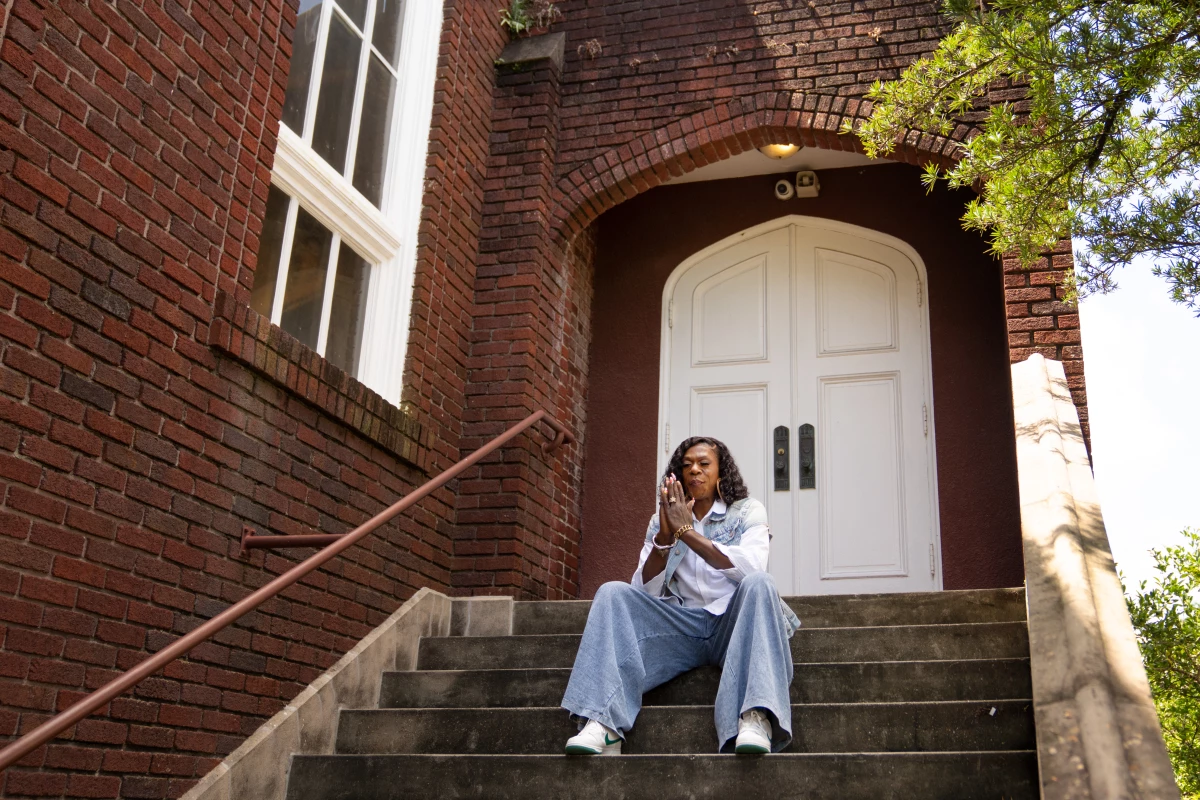 Big Freedia clasps her hands on the steps of the converted church in New Orleans.