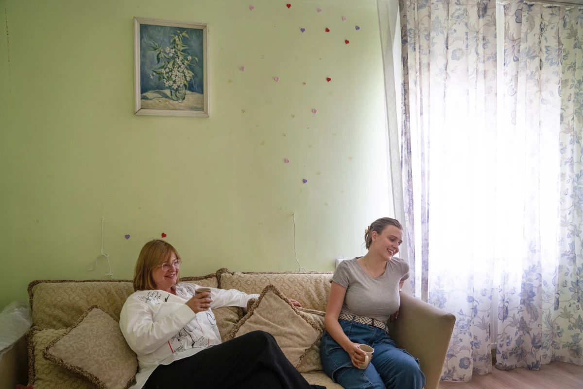 Iryna Schestova, 50, and her daughter, Liia Kazakova, 26, sit in the living room of a friend's home in Horenychi, a suburb of Kyiv, Ukraine. Kazakova is staying in the home instead of with her mother because she can't sleep at night listening to the sounds of war from her mother's apartment in central Kyiv.