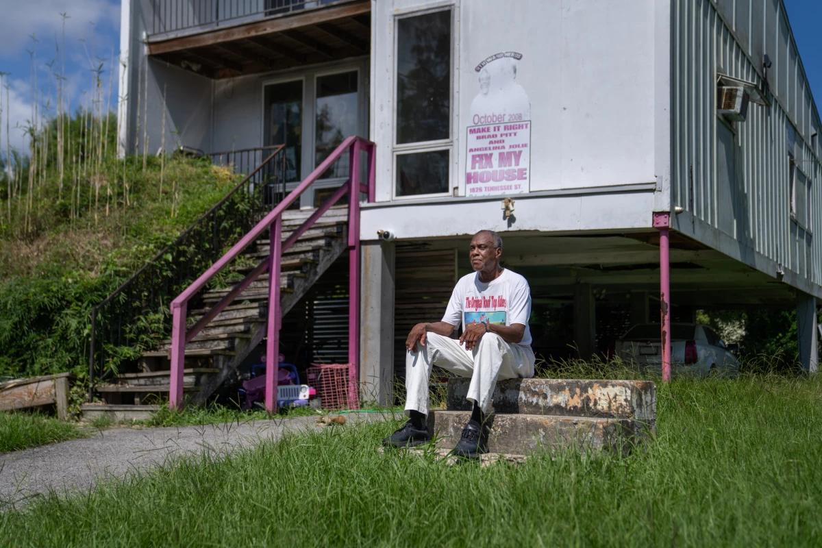 Robert Green sits on the concrete steps, all that remains from his original home in the Lower Ninth Ward. During Katrina, his house floated away in the flooding, and family members died. A new home was built by the Make It Right Foundation, but the new construction was filled with flaws.