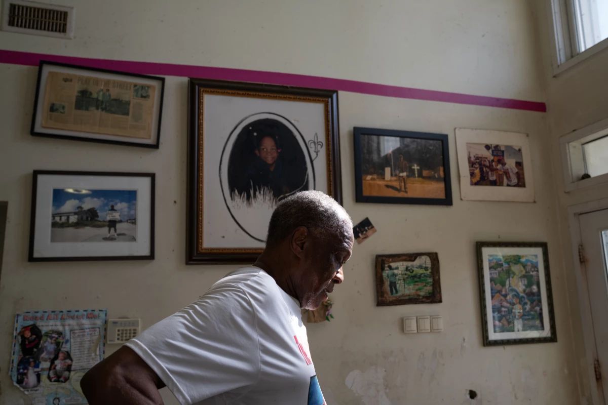 Robert Green and his family were stranded on rooftops when Katrina hit. The pink line on the wall behind him marks how high water rose.