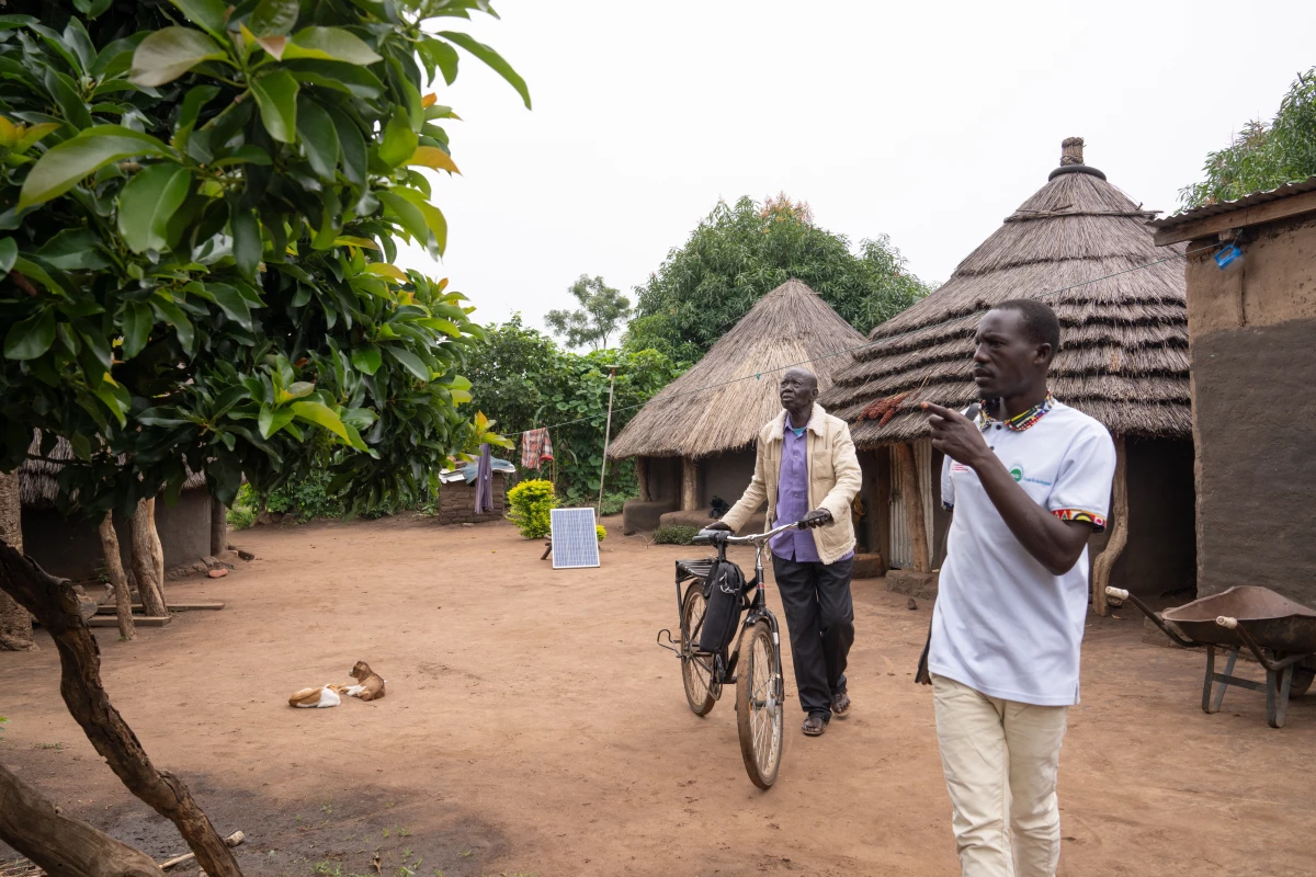 Akim Joseph Yanga, left, speaks with with Bosco Okot, who began working with with AVSI's program in Palabek as a coach to help people build small businesses until the program was terminated as a result of USAID funding cuts.