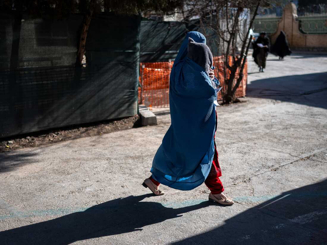 A woman in Herat, wearing a burqa, This photograph taken on January 8, 2026 shows an Afghan burqa-clad woman walking with her child at the Medecins Sans Frontieres (MSF) centre inside a hospital in Herat. In the country of more than 40 million people, there are relatively few medical centres that can help treat malnutrition. Some families travel hundreds of kilometres (miles) to reach Herat hospital as they lack healthcare facilities in their home provinces.