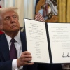 President Trump holds up a signed executive order relating to clemency for anti-abortion protesters in the Oval Office in January.
