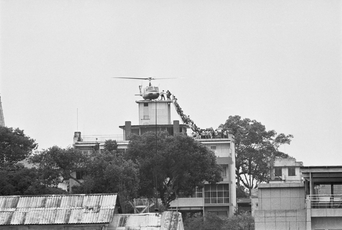 A CIA employee helps Vietnamese evacuees onto an Air America helicopter from the top of 22 Gia Long St., a half mile from the U.S. Embassy.