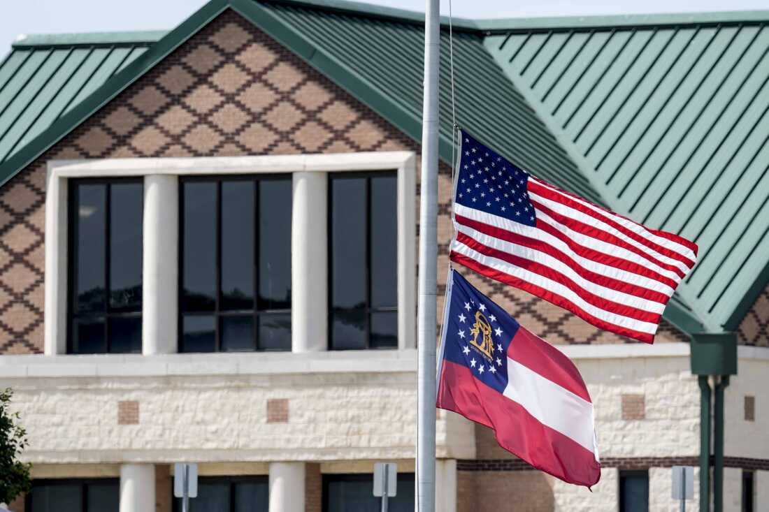 The American and state of Georgia flags fly half-staff on Thursday after a shooting at Apalachee High School in Winder, Ga.