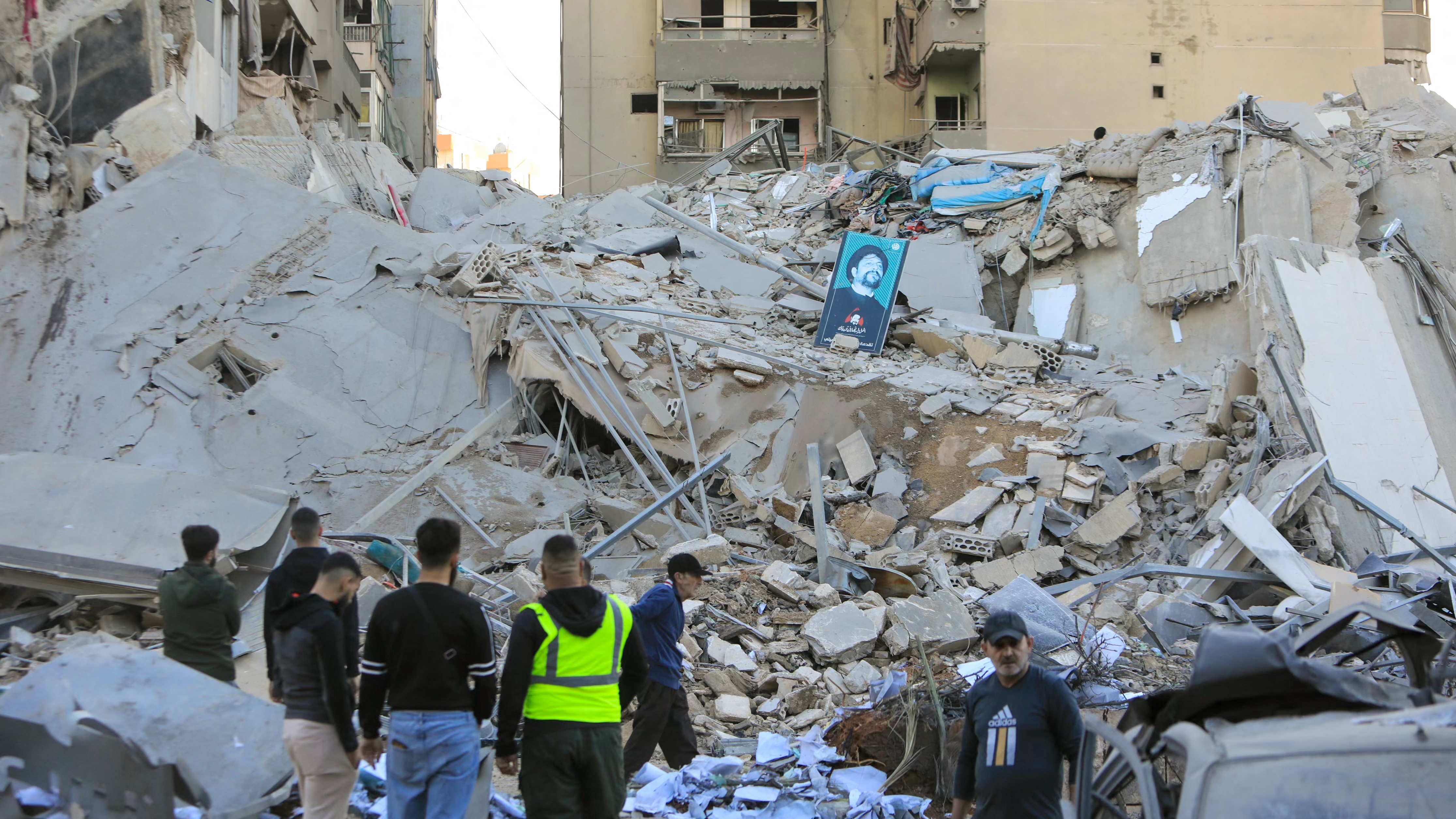 People inspect the damage at the site of an overnight Israeli airstrike that targeted a branch of the Al-Qard Al-Hassan finance group in Beirut