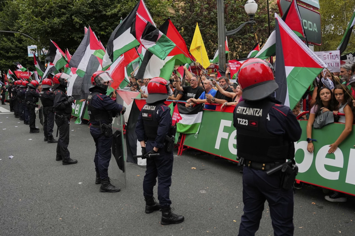 People hold Palestinian flags during the eleventh stage of the Spanish Vuelta cycling race, from Bilbao to Bilbao, Spain, Wednesday, Sept. 3, 2025.