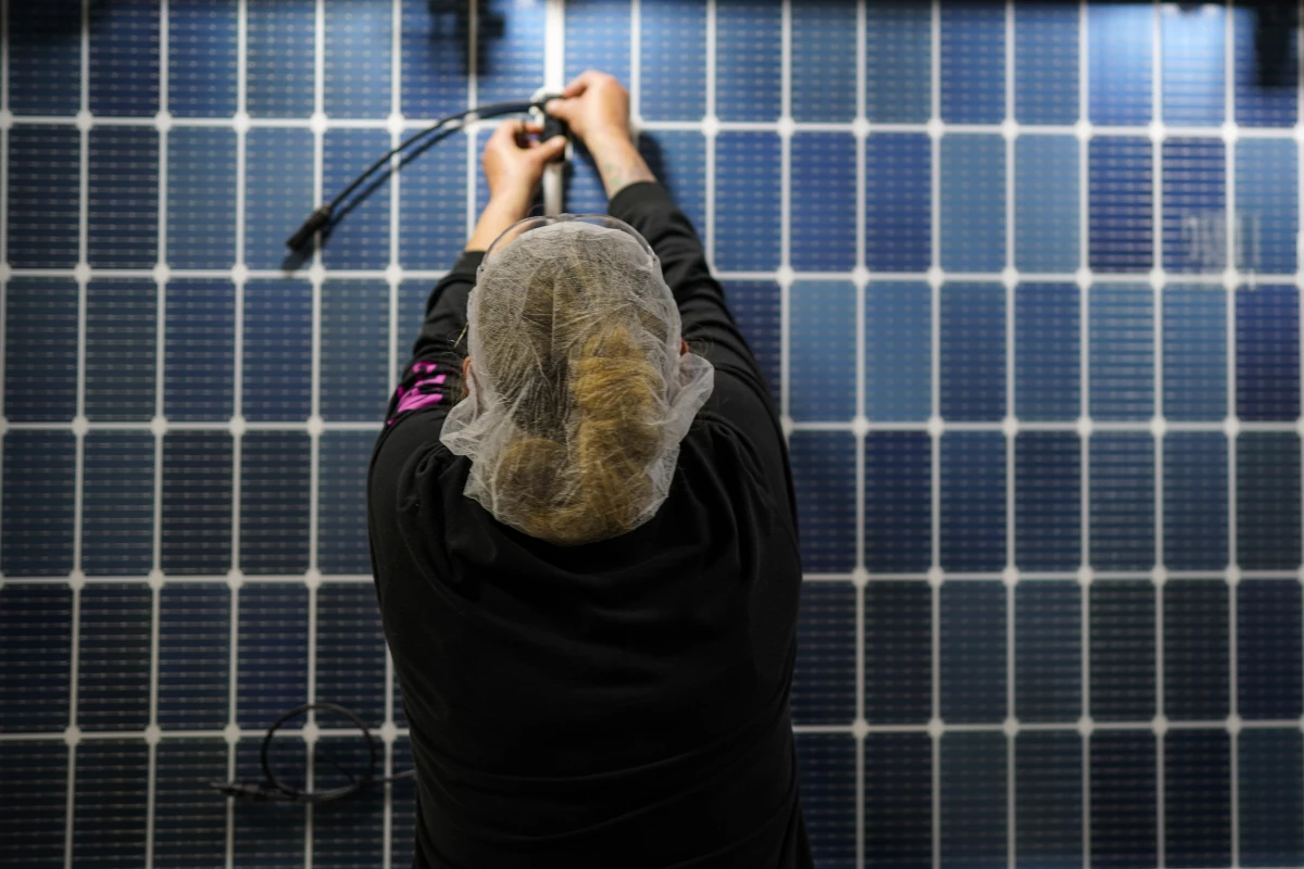An employee works on a solar panel inside a Qcells factory in Dalton, Ga.