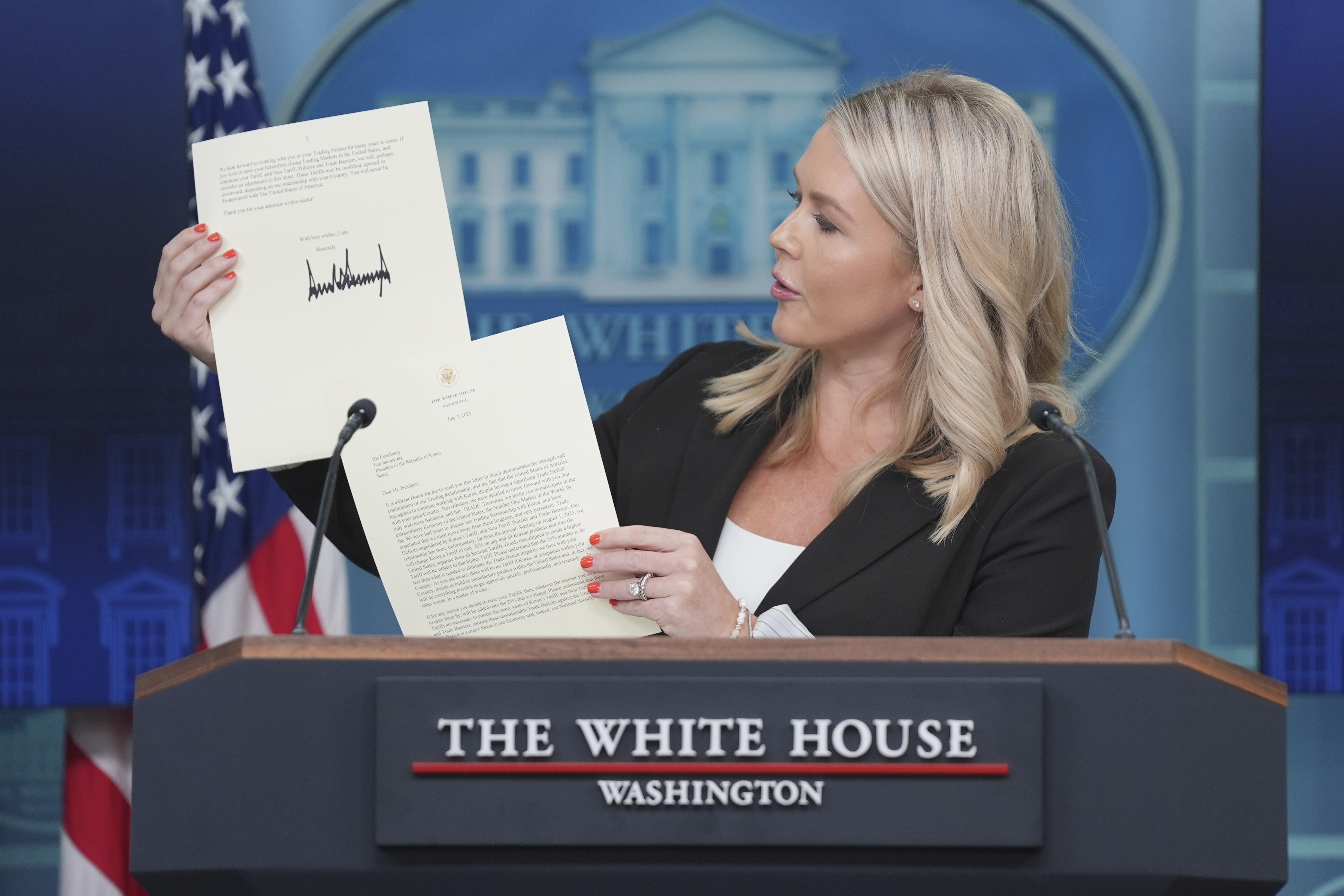 White House press secretary Karoline Leavitt holds up a tariff letter from President Trump to South Korea's President Lee Jae-myung during a press briefing at the White House on July 7. (AP)