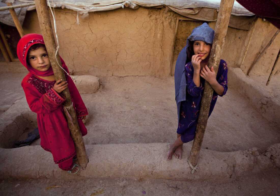  Zareena, left, and Shakeela, internally displaced Afghan girls play outside a shanty at a refugee camp in the outskirts of Kabul, Afghanistan, Monday, July 25, 2011.